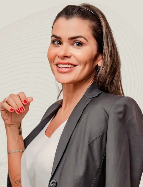 Dra. Maira Veran, endodontista, sorrindo de blazer cinza